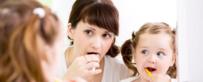 mother teaching kid teeth brushing